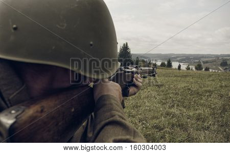 PERM RUSSIA - JULY 30 2016: Historical reenactment of World War II summer 1942. Soviet soldier aiming a rifle