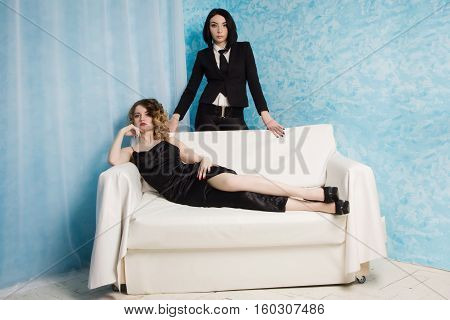 Two Fashionable Girls Sitting On The Armchair