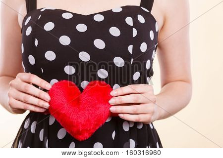 Valentine day gift proof of love romantic present concept. Woman in retro polka dot dress holding small furry red heart