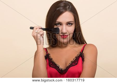 Young model woman posing with brush for costemics for doing perfect makeup isolated on white background. Cosmetics concept.