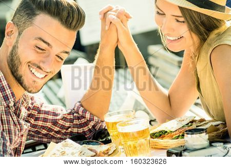 Couple in love taking selfie at beer bar on travel excursion - Young happy tourists enjoyng happiness moment at street food restaurant - Relationship concept with soft focus and desat contrast filter