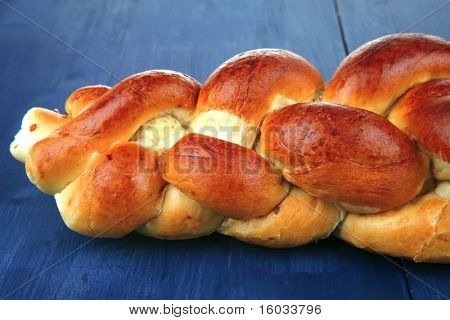 makea leipä: golden challah yli sininen puinen levy