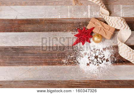 Christmas decoration gift and snowflake on the wooden background