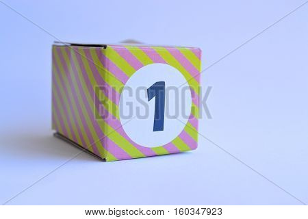 small stripey cardboard box with the number one 1 printed on it
