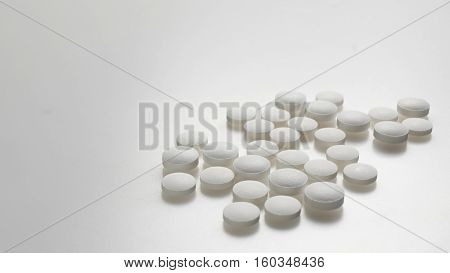white round pills forming a pattern on a white background