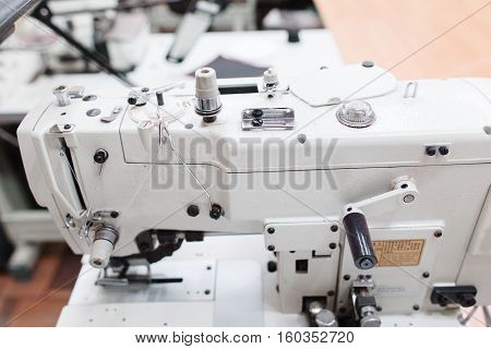 Coverstitch sewing machine close-up. Fashion designer equipment in tailor workshop. Industrial, occupation, clothes making concept