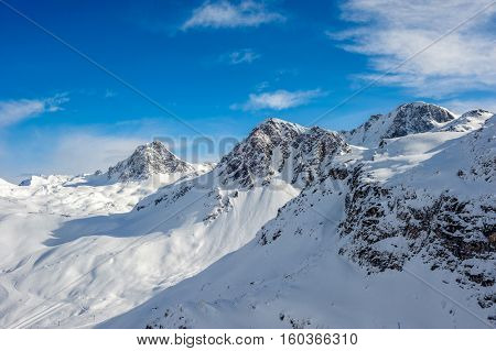 Alpine winter mountain landscape. French Alps covered with snow in sunny day. Val-d'Isere, France