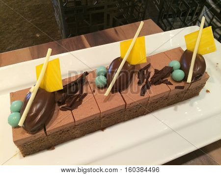 Homemade chocolate mousse cake on the tray decorate with white chocolate stick (focus on the right side)
