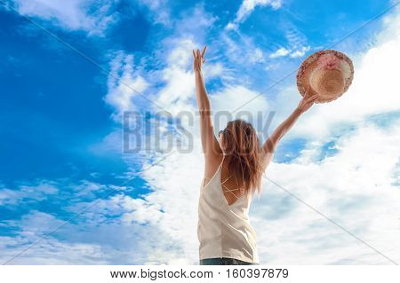 back view of woman with hat looking at blue skysummer vacation concept