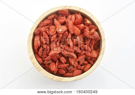 goji berry in wooden cup on white background.