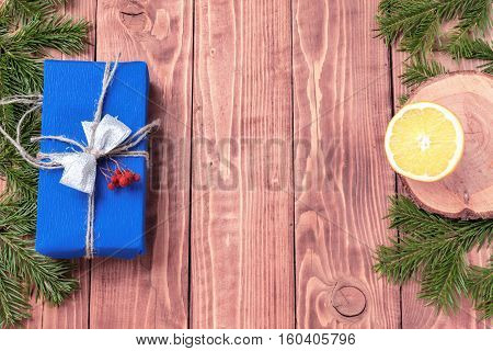 Christmas New Year composition with tangerines, cones, nuts, wicker basket and fir branches in rustic style on old wooden background, selective focus, Background new year, fir, gift, cones, orange, blue ball, red background