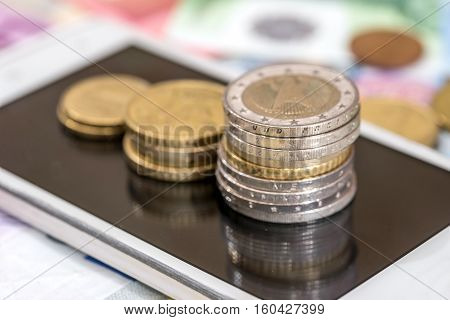 Euro coin money and white phone for background
