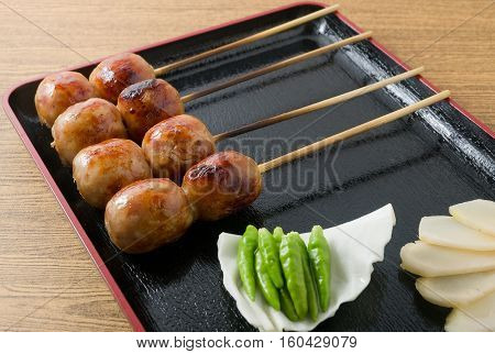 Food and Cuisine A Tray of Thai Grilled Sausages on Wooden Skewer Served with Slice Ginger Cabbage and Chili Pepper.