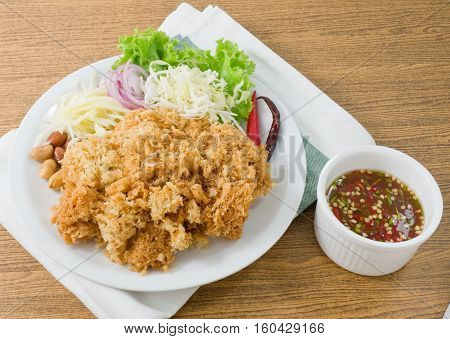 Thai Cuisine and Food Thai Traditional Crispy Catfish Salad Served With Green Oak Shredded Green Mango Red Onion Cabbage Chili Peanut and Spicy Sauce.