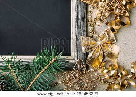 Golden Christmas decorations and fir branches on black matte background New Year frame top view copy space