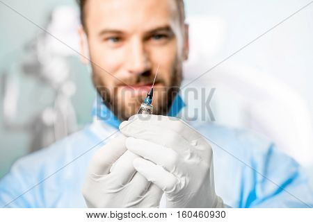 Surgeon holding small surgical scissors for eye operation in the operating room. Image with small deph of field focused on hands and scissors