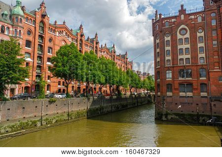 HAMBURG, GERMANY - JULY 18, 2015: canal of Historic Speicherstadt houses and bridges at evening with amaising skyview over warehouses, famous place on Elbe river.