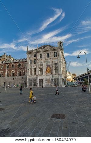 GENOA, ITALY - JUNE 2, 2015: Unidentified people by Palazzo San Giorgio in Genoa Italy. Palace was built in 1260 and facade was refrescoed in the late 19th century
