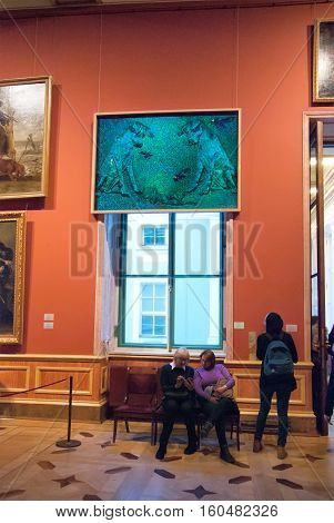 St Petersburg, Russia, Dec 1, 2016: People sit under the exhibit of temporary modern art exhibition 