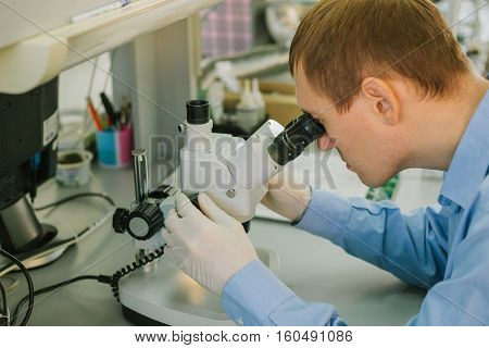 Expert looking through a microscope in a laboratory