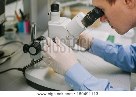 Expert looking through a microscope in a laboratory