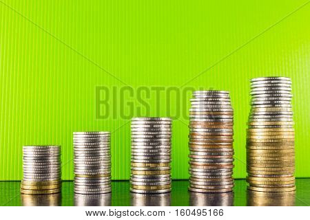 Pyramid gold and silver coins on a green background and dark desktop