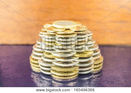 The pyramids of gold and silver coins on brown blurred background. Business concept growth Finance.