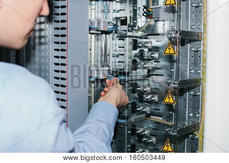 Electrician near the low voltage cabinet. Uninterrupted power supply. Electricity.