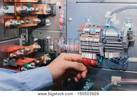 Electrician near the low voltage cabinet. Uninterrupted power supply. Electricity.