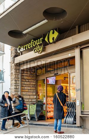 STRASBOURG FRANCE - DEC 1 2016: People entering Carrefour supermarket at the evening to buy diverse food and non-food products. Carrefour is the largest chain of stores in France