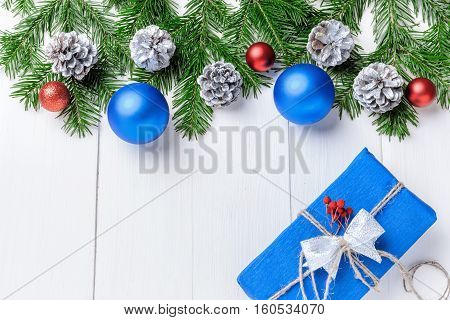 Christmas New Year composition with tangerines, cones, nuts, wicker basket and fir branches in rustic style on old wooden background, selective focus, Background new year, fir, gift, cones, orange, blue ball, red background, snow, ,