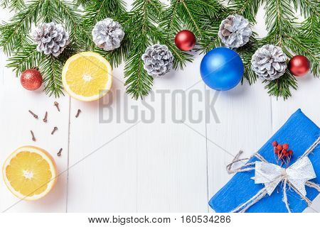 Christmas New Year composition with tangerines, cones, nuts, wicker basket and fir branches in rustic style on old wooden background, selective focus, Background new year, fir, gift, cones, orange, blue ball, red background, snow, ,