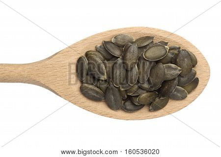 Pumpkin seeds in a wooden spoon isolated on white background