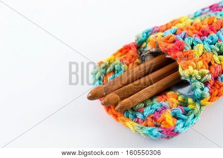 Wooden crochet hooks in crochet bag isolated on white background