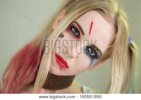 Cosplayer girl in Harley Quinn makeup and costume