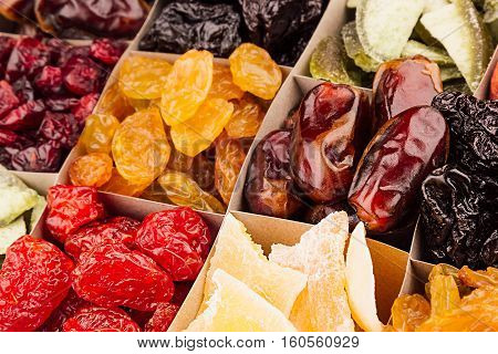 Assortment of dried fruits closeup background in square cells. Decorative pattern of dry exotic fruit. Top view.