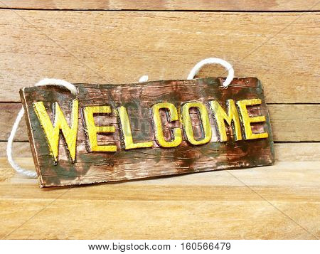 colorful welcome sign hanging on wooden background