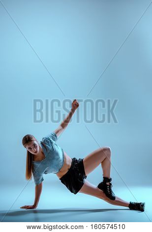 Attractive girl dancing twerk iat the blue studio background