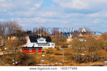 Helsinki. Finland. Wooden houses in Suomenlinna (Sveaborg) Fortress on Susisaari Island. On the background is the church-lighthouse
