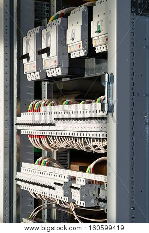 Connecting cables with cable lugs to circuit breakers in the electrical control panel on the artboard. Alignment of the components to ensure safety and reliability.