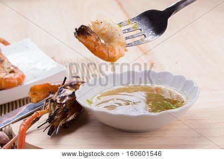 Burn Shrim And Seafood Sauce On Wooden Table.