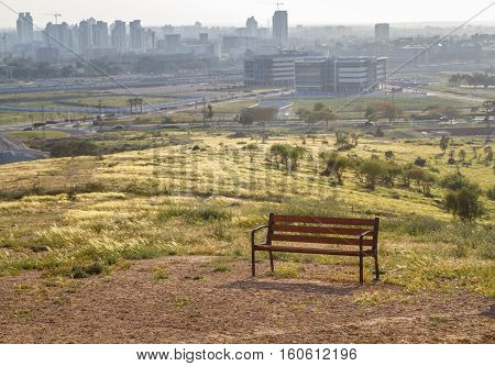 Bench on a hilltop overlooking the Be'er Sheva city in the Negev desert Israel