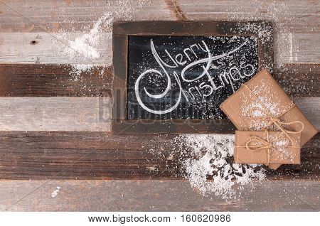 Christmas decoration and gift boxes with space for greeting Merry Christmas on chalk blackboard.