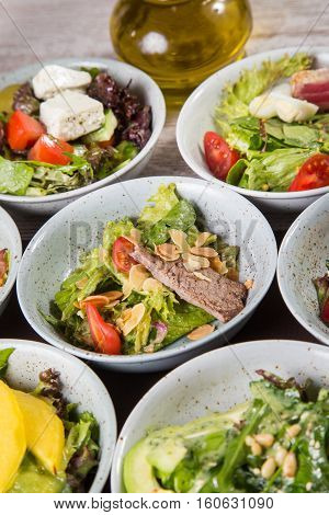 some fresh salad with many ingredients mixed in grey dish