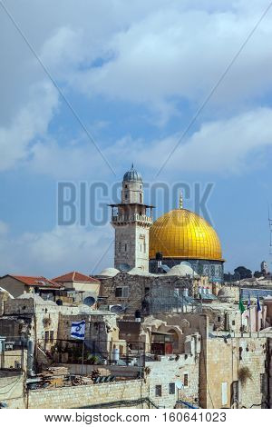 Jerusalem, Israel. Mosque Golden dome of the Qubbat al-Sakhra and roofs of old houses with the flag of Israel