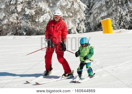 Little boy learning how to ski. skiing together