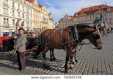 PRAGUE, CZECH REPUBLIC - OCTOBER 4, 2015: Horse drawn carriage and cabman on Old Town square in Prague, Czech Republic.