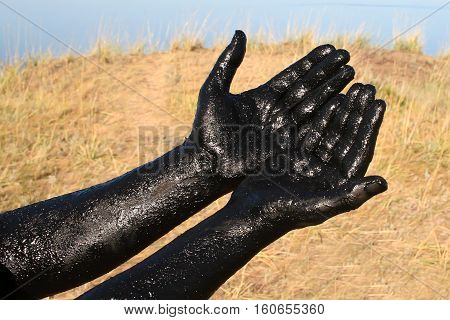 Therapeutic mud / Hands covered with therapeutic mud. Salt lake in the Altai region.