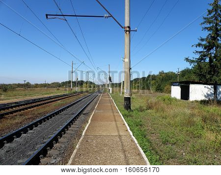 Double-track railway runs past the stopping point platform.