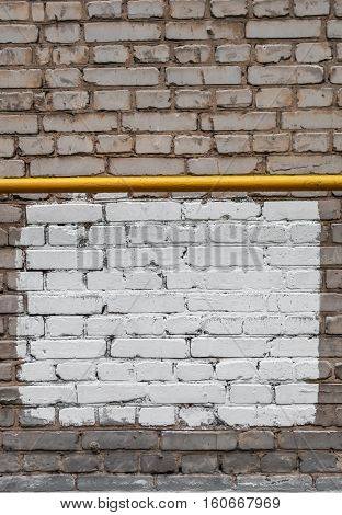 Yellow pipe on a brickwall with white rectangle for the abstract background with frame
